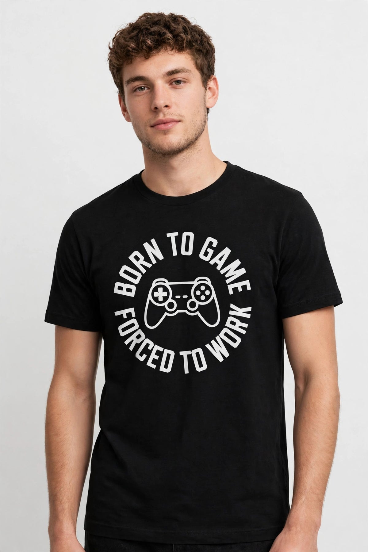 Editorial shot of a model in the Born To Game, Forced To Work black unisex t-shirt against a white wall