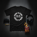Flat lay of Born to Game Forced to Work tee with gaming accessories