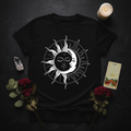Flat lay of Celestial Sun tee with crystals, dried flowers and candle