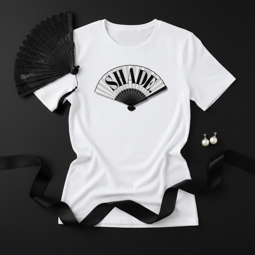 Flat lay of Shade. tee with black fan and pearl accessories